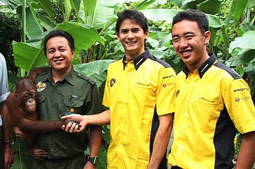 Afbeelding: Alex Yoong schudt een orang-oetan de hand."