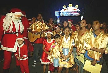 Image: Christmas cheer: Carollers singing festive songs as they visit homes in the settlement on Thursday night."