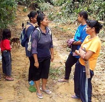 Image: Off we go: The orang asli women visit the forest daily to tap rubber and pick fruits."
