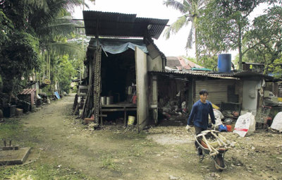 Afbeelding: Een bewoner van Kampong Buangkok haalt spullen weg uit zijn huis."