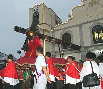 Image: Members of the Irmaos de Igreja carring the statue of Christ carrying the cross."