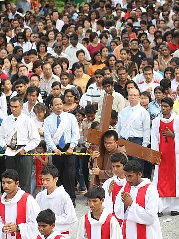 Image: Reverend Gompok carrying the cross while SFA Church parishioners pray during the Ways of the Cross procession in Cheras, Kuala Lumpur on Friday."