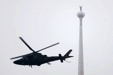 Image: Alain Robert standing on the tip of Malaysia's Petronas Twin Towers."