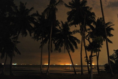 Image: Lights from the fleet of ships illuminate the night-time horizon."