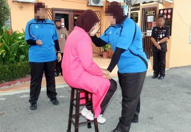 Afbeelding: Gevangenispersoneel demonstreert het voltrekken van een lijfstraf."