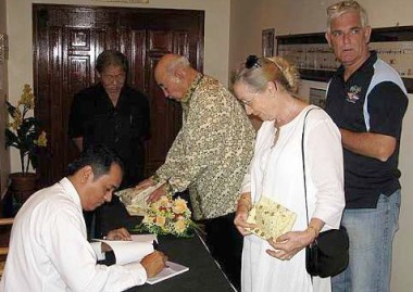 Image: Personal signature: De Witt (seated) authographing his book after its launching recently."